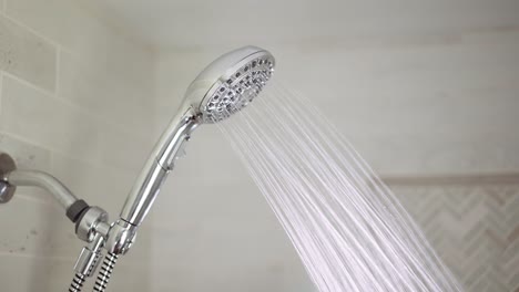 chrome shower head is turned on where hot water comes out and then turned off again