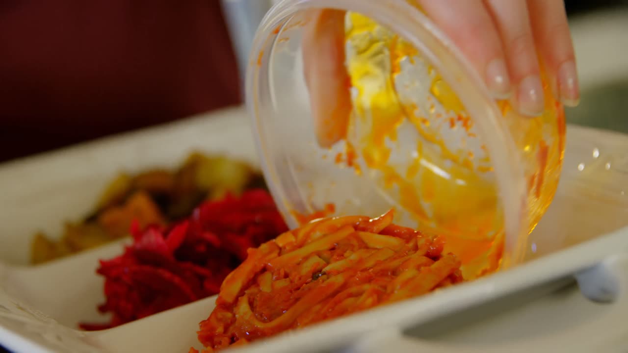 접시 에 음식 을 넣고 있는 여자 의 클로즈업 4k