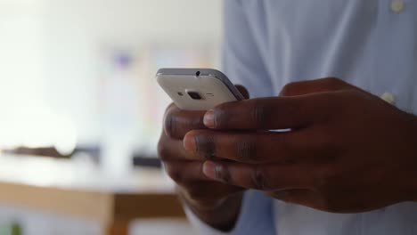 Close-up-of-young-black-businessman-working-on-smartphone-in-a-modern-office-4k