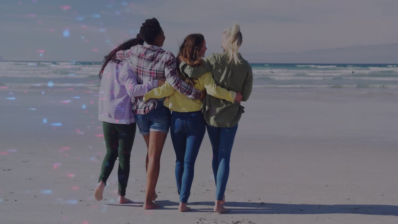 Gruppo di amici che si tengono per braccio ed entrano tra le onde, sentendo le onde leggere, mostrando una connessione di stile di vita.