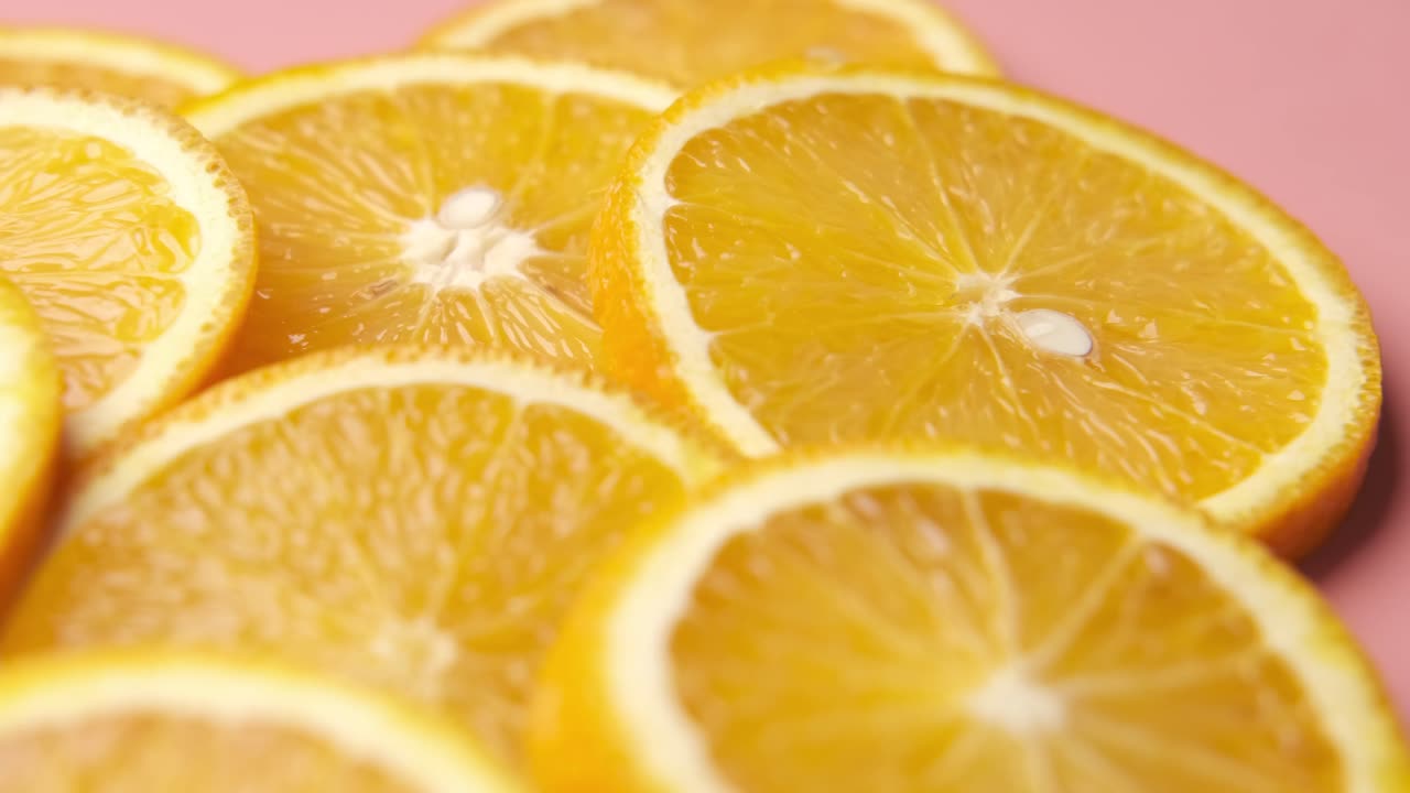 Nahaufnahme von Orangenscheiben auf einer pinken Oberfläche