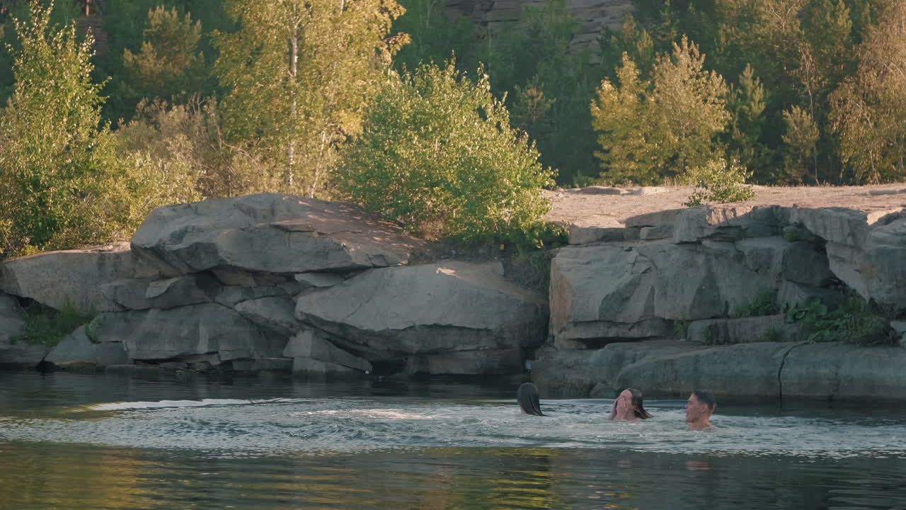 Young Men and Women Jumping into Lake