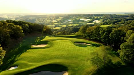 aerial view of a beautiful golf course with green grass, trees, and a blue sky