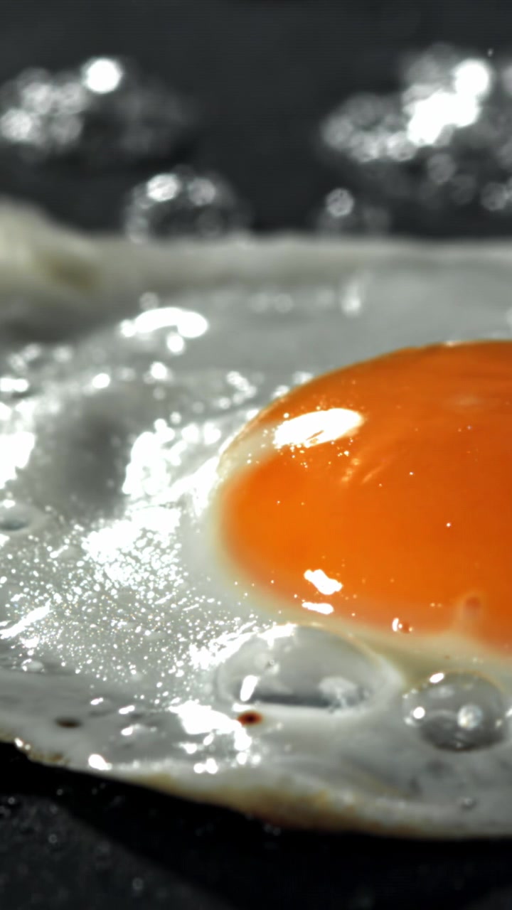 Close-up of a Fried Egg Sizzling in a Hot Pan