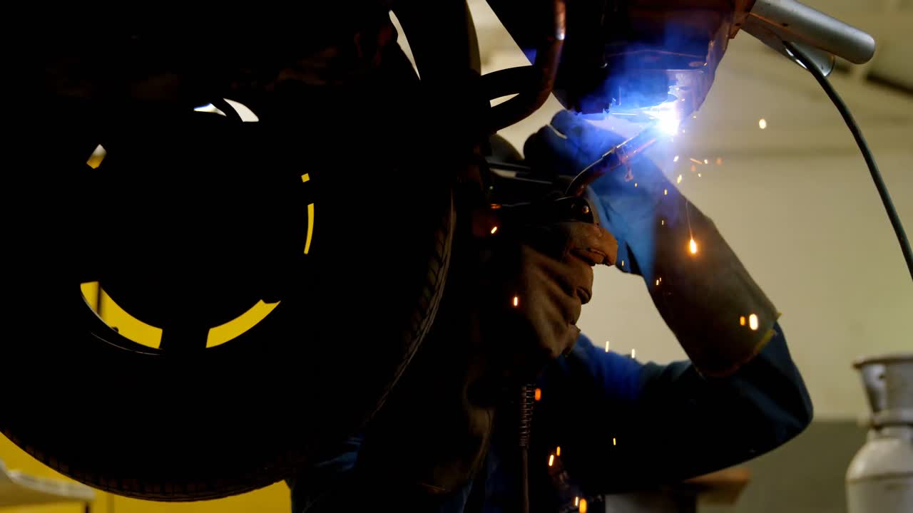 Premium stock video - Mechanic using wielding torch on a car 4k
