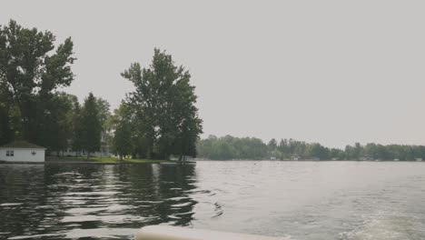 pov of a sailing boat with mirror reflection on pristine lake