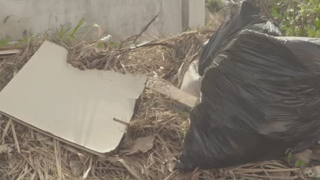 bolsa de basura y pared seca tirada en el campo