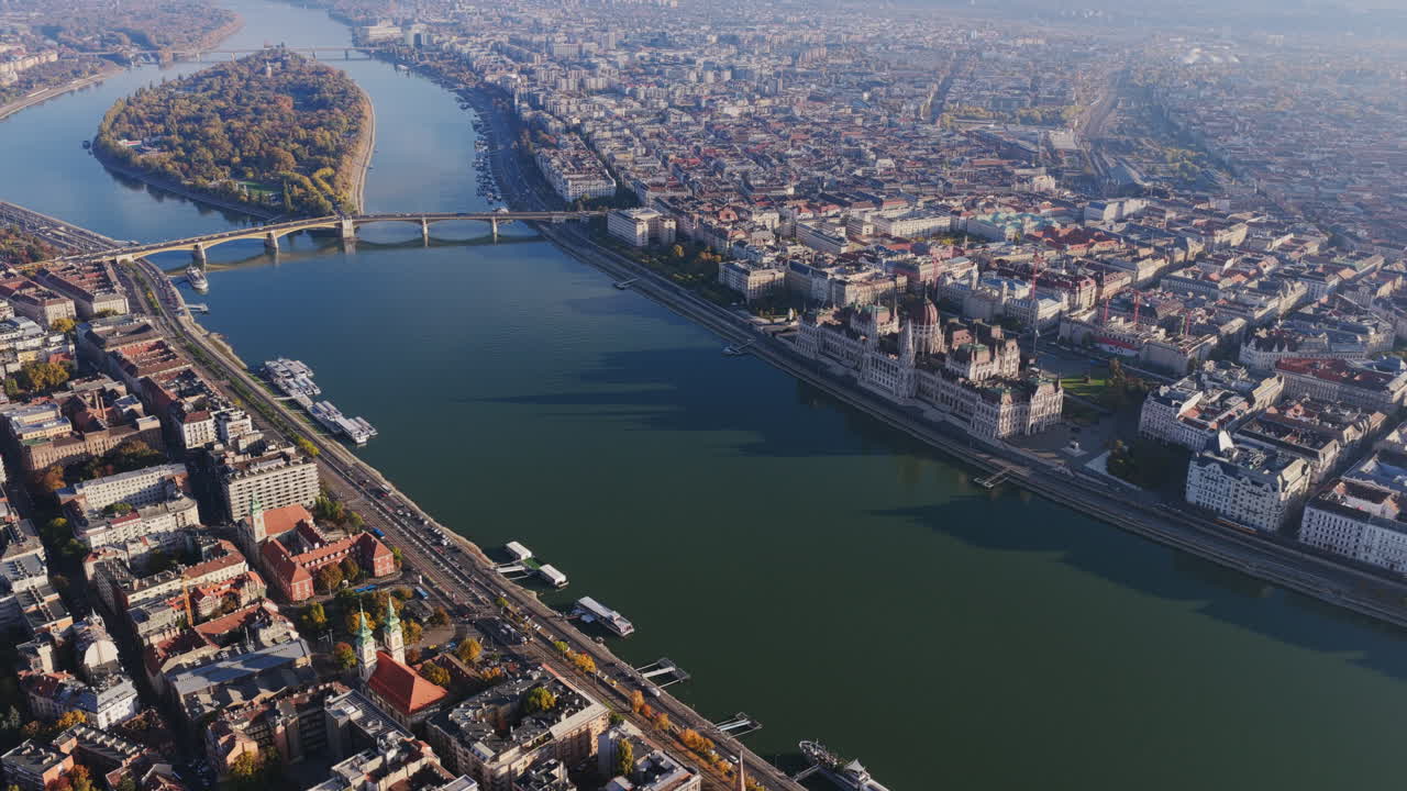 Aerial shot of the Hungarian Parliament Building along the Danube with Margaret Island and bridges visible amid Budapest’s elegant riverside layout