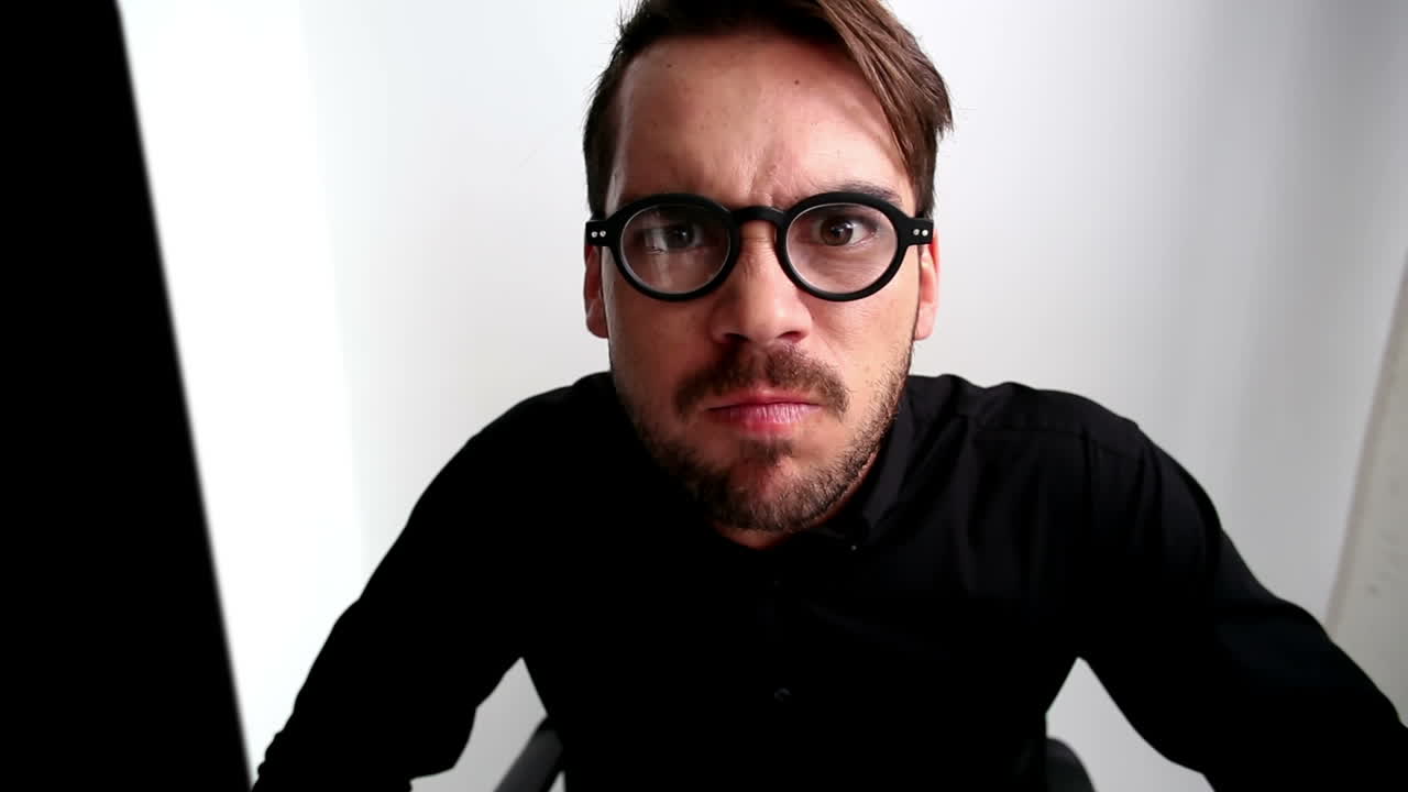 un hombre de negocios nerd escribiendo y enojándose.