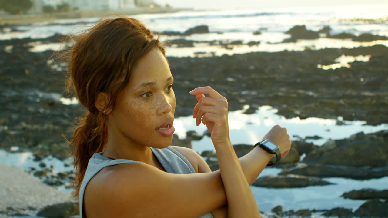 mujer haciendo ejercicio en la playa al anochecer 4k