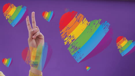 mano haciendo signo de paz sobre arco iris corazones animación en fondo púrpura