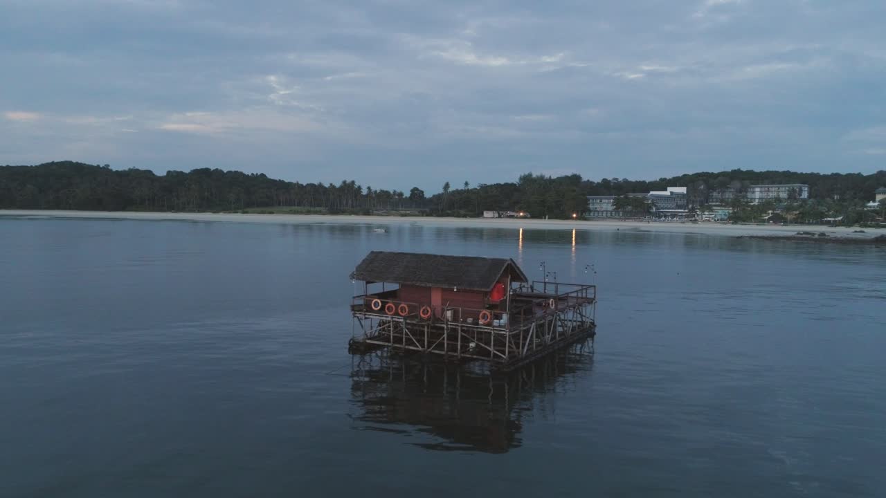 열대 해변 의 조용 한 물 에 떠다니는 집