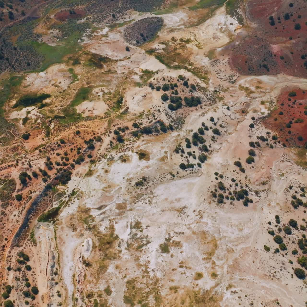 Unusual colorful landscape of Travertine Hot Springs, California, USA. Few cars parked at the road end. Aerial view