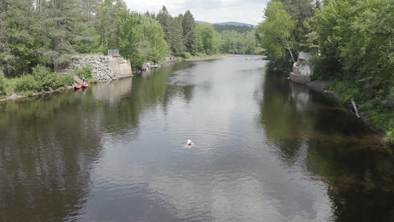 Vacker sommarscen, en flicka simmar under en fin dag i floden