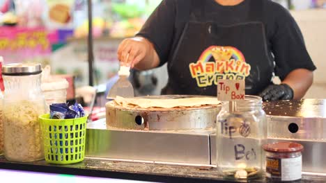 vendor prepares crepes at night market stall