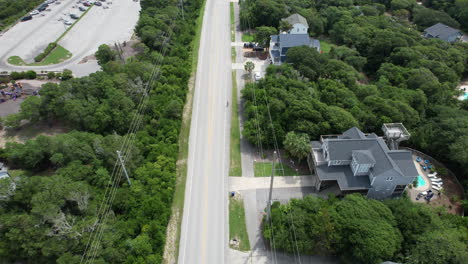 Drone-shot-of-person-riding-a-bike-on-a-coastal-highway