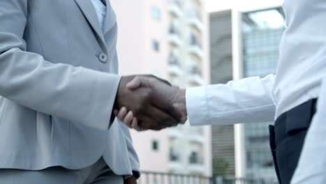 dos empleados dándose la mano al aire libre