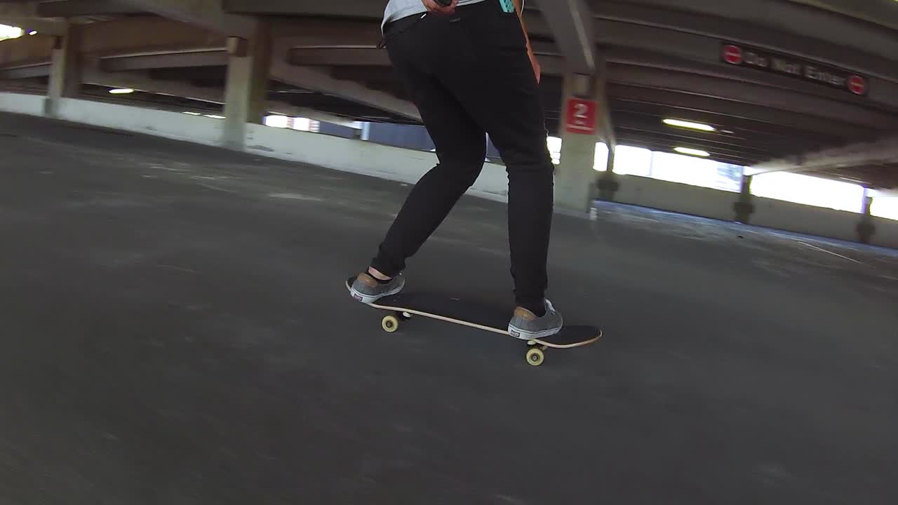 Person riding a skateboard down a parking garage