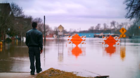 Inundación-Dramática-Hombre-Camina-Camino-Cerrado-Agua-Huracán-Cambio-Climático-Autos-Indefensos-Desastre-Destrucción-Alivio-De-Inundaciones-4k-60fps