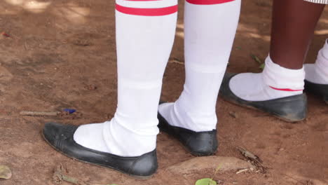 Jóvenes-Estudiantes-Africanas-Vestidas-Con-Uniforme-Universitario,-De-Cerca-Con-Zapatos-Negros-Y-Calcetines-Rojos-Blancos