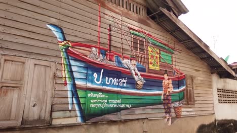 local graffiti on the wooden house's wall in a fisherman village, chonburi, thailand