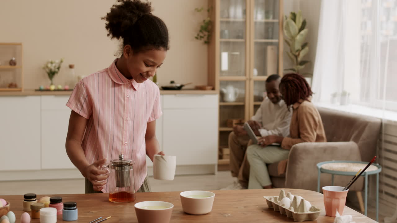 chica africana vertiendo té para los padres
