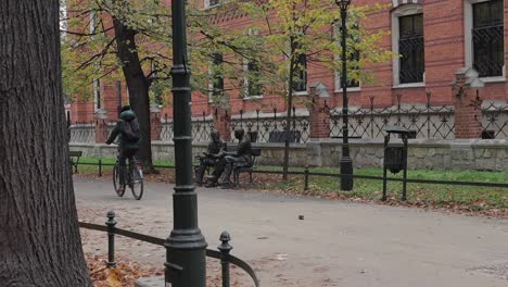 a cyclist rides down the street next to the castle in krakow