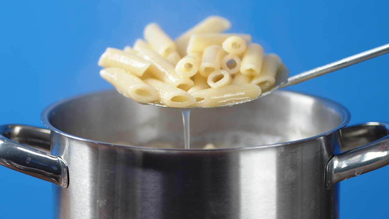 la pasta de penne hervida fuera de la sartén.