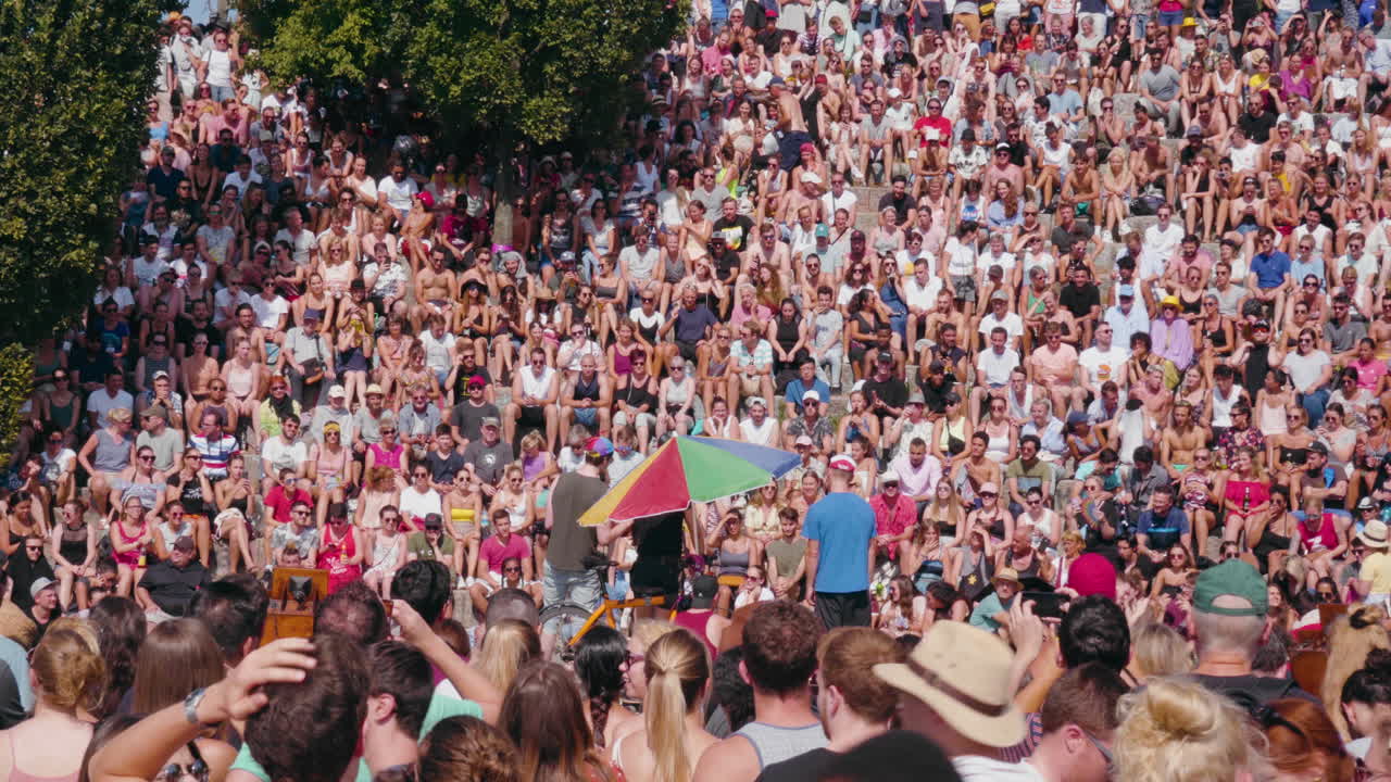 Large crowd of people gathered in Summer at a Sunday Karaoke session at Mauerpark in Berlin, Germany. Circa 2018. 4K