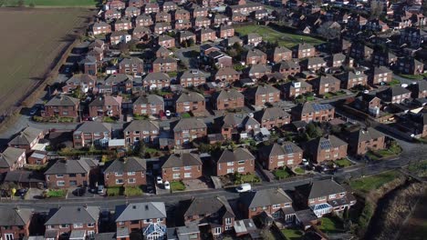 Typical-Suburban-village-residential-Scottish-neighbourhood-property-rooftops-aerial-view-slow-descend