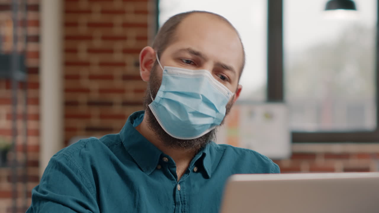 Man working at desk with face mask on
