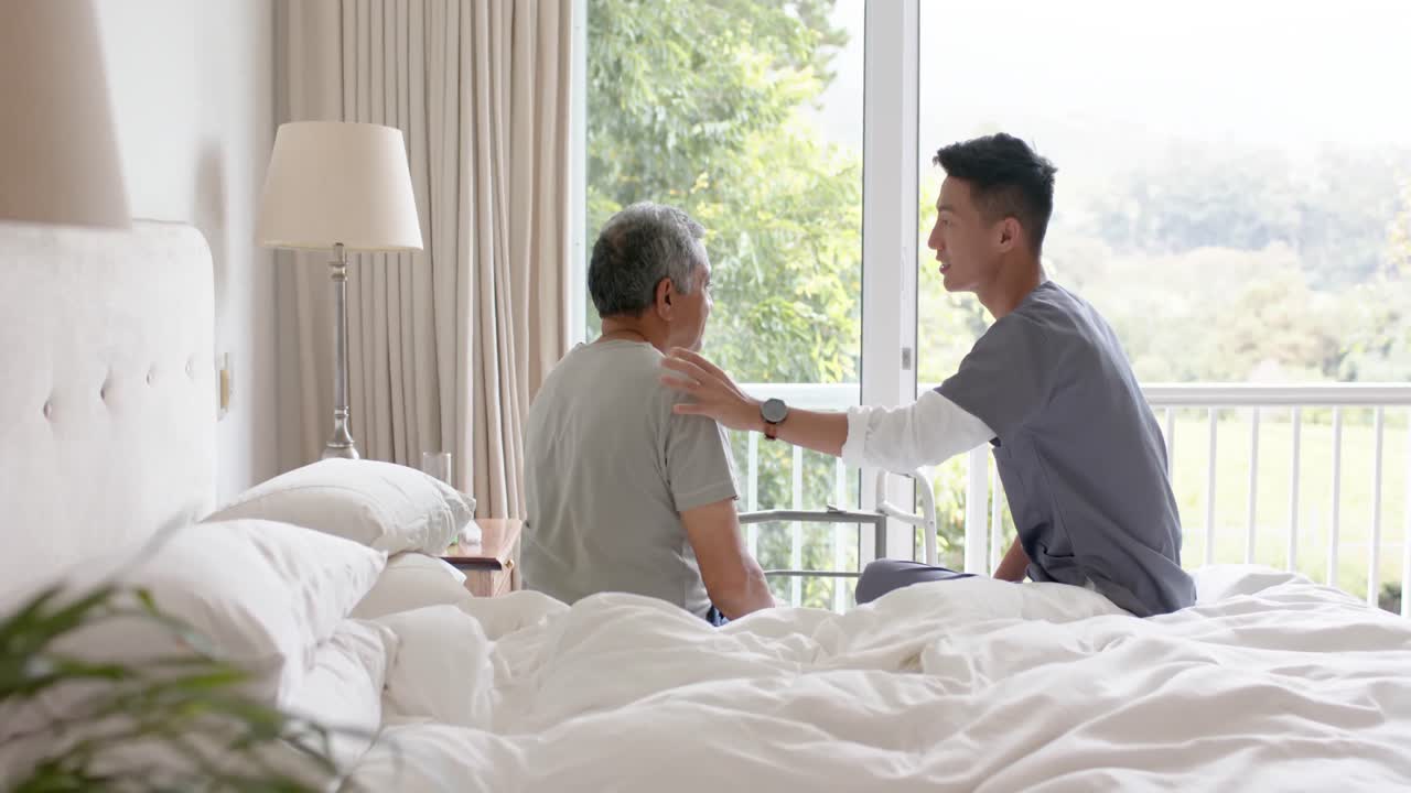 다양한 남성 의사가 고령 남성 환자와 함께 집에서 침대에서 논의하고, 느린 동작