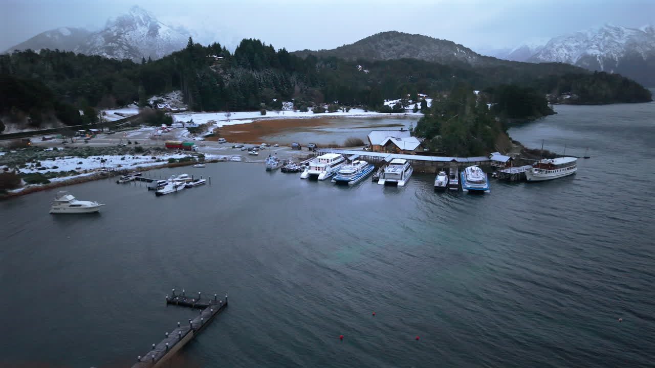 Panoramic aerial movement around the Puerto Panuelo passenger port at the Llao Llao peninsula in winter, Bariloche, Argentina