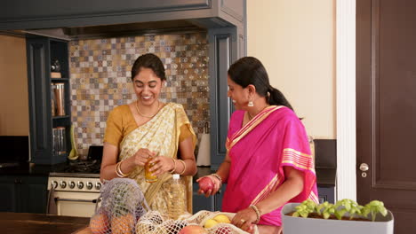 preparing meal, indian mother and teenage daughter in traditional sari cooking together in kitchen