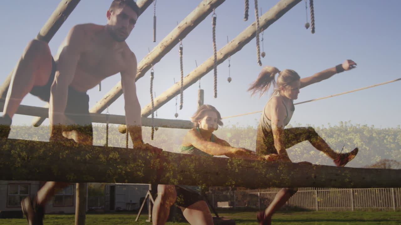 Navigating obstacle course, athletes using ropes and wooden beams outdoors