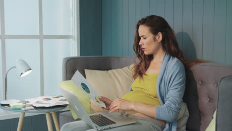 close up pregnant woman feeling baby movement in her belly indoors.