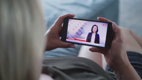 mujer viendo noticias en línea en un teléfono inteligente