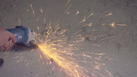 worker using angle grinder to remove nails in construction floor