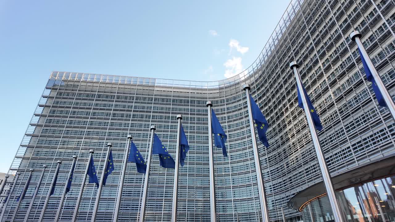 Panning shot of Berlaymont and EU flags on a sunny morning in Brussels