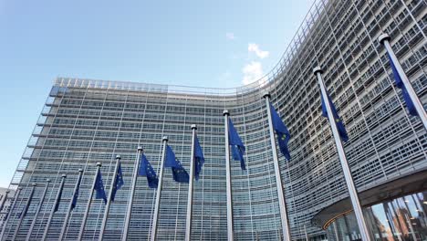 panning shot of berlaymont and eu flags on a sunny morning in brussels
