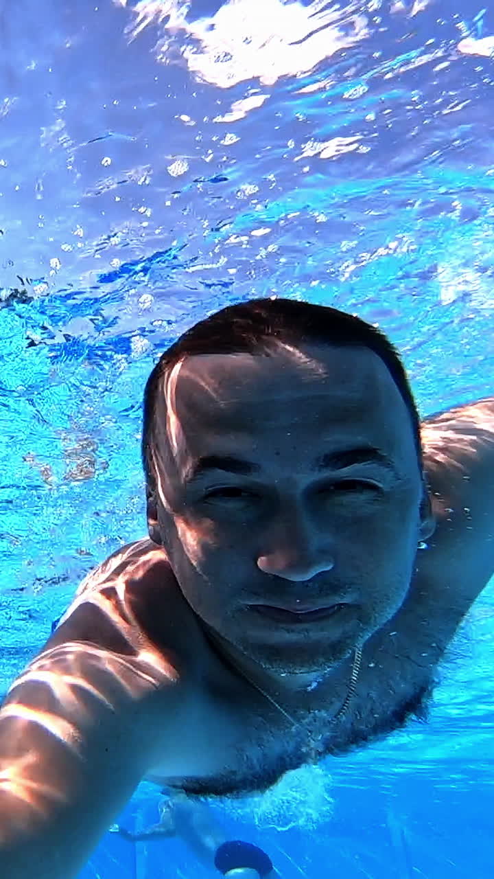 hombre nadando bajo el agua en una piscina
