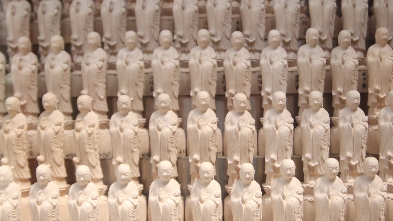Nærbillede af rækker af små buddhistiske figurer ved Ryozen Kannon i Kyoto, der skaber et gentagende andagtsmønster inden for mindekomplekset i det historiske Higashiyama-distrikt.