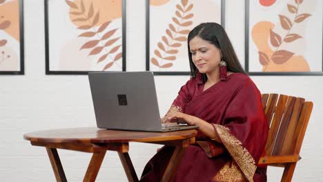 happy indian woman working on laptop