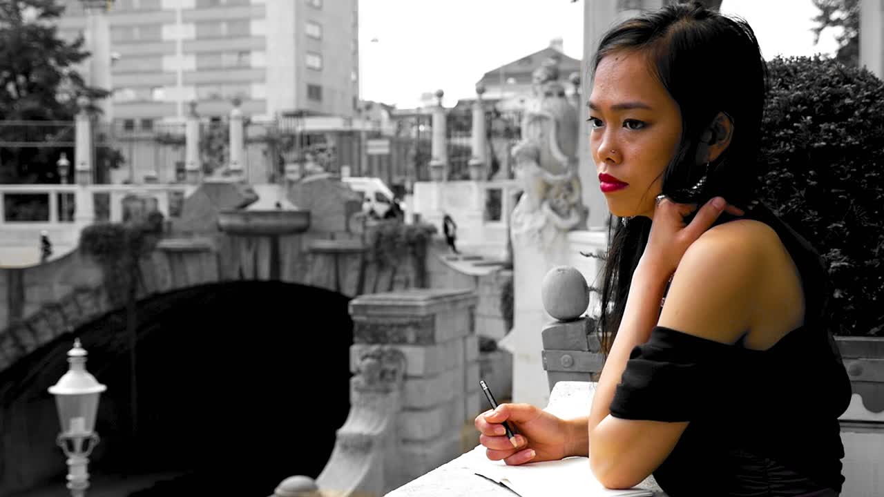 선택적인 색을 입은 여성이 비엔나의 스타트파크, 다리와 배경의 조각품, 도시 환경을 상하고 있습니다.