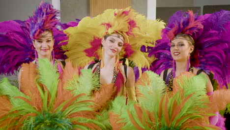 showgirls with feather fans looking and smiling to the camera 1