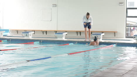 swimming coach giving instructions at the poolside, with copy space