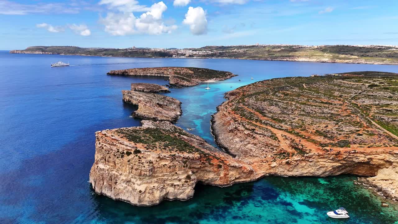 Den blå lagune i Comino, Għajnsielem, Gozo-regionen, Malta, med kalksteinsklipper og garrigue-vegetasjon inkludert habitat for Thymbra capitata og Euphorbia dendroides over klart middelhavsvann, luftfoto.