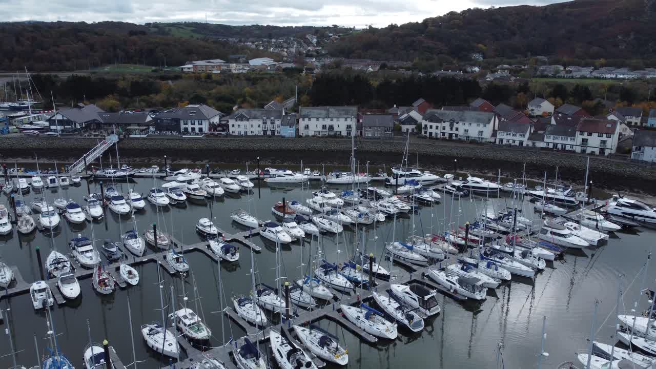 pintoresco puerto de lujo frente al mar apartamento pueblo yates y veleros bajo la costa de la montaña vista aérea izquierda en órbita