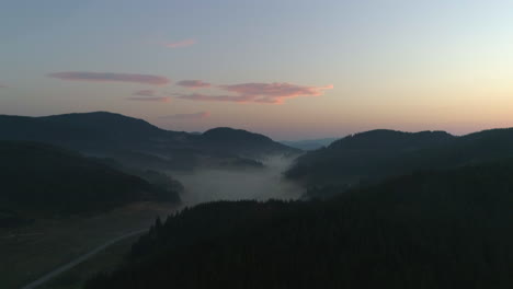 a road in the mountains enveloped by mist early in the morning