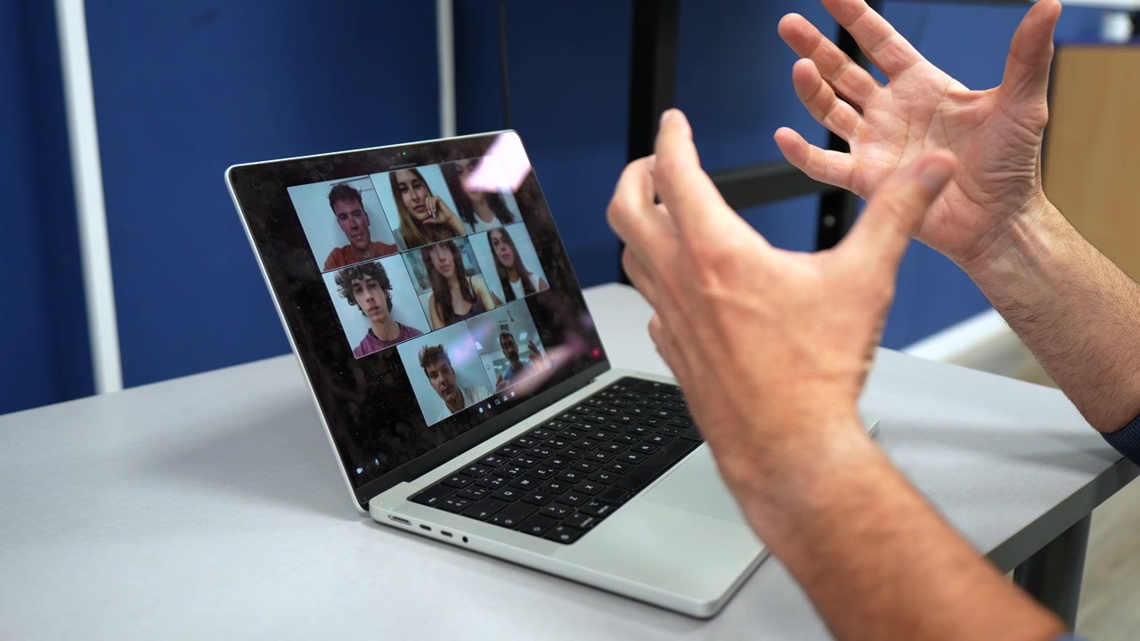 Man's Hands Gesturing During a Virtual Meeting on Laptop